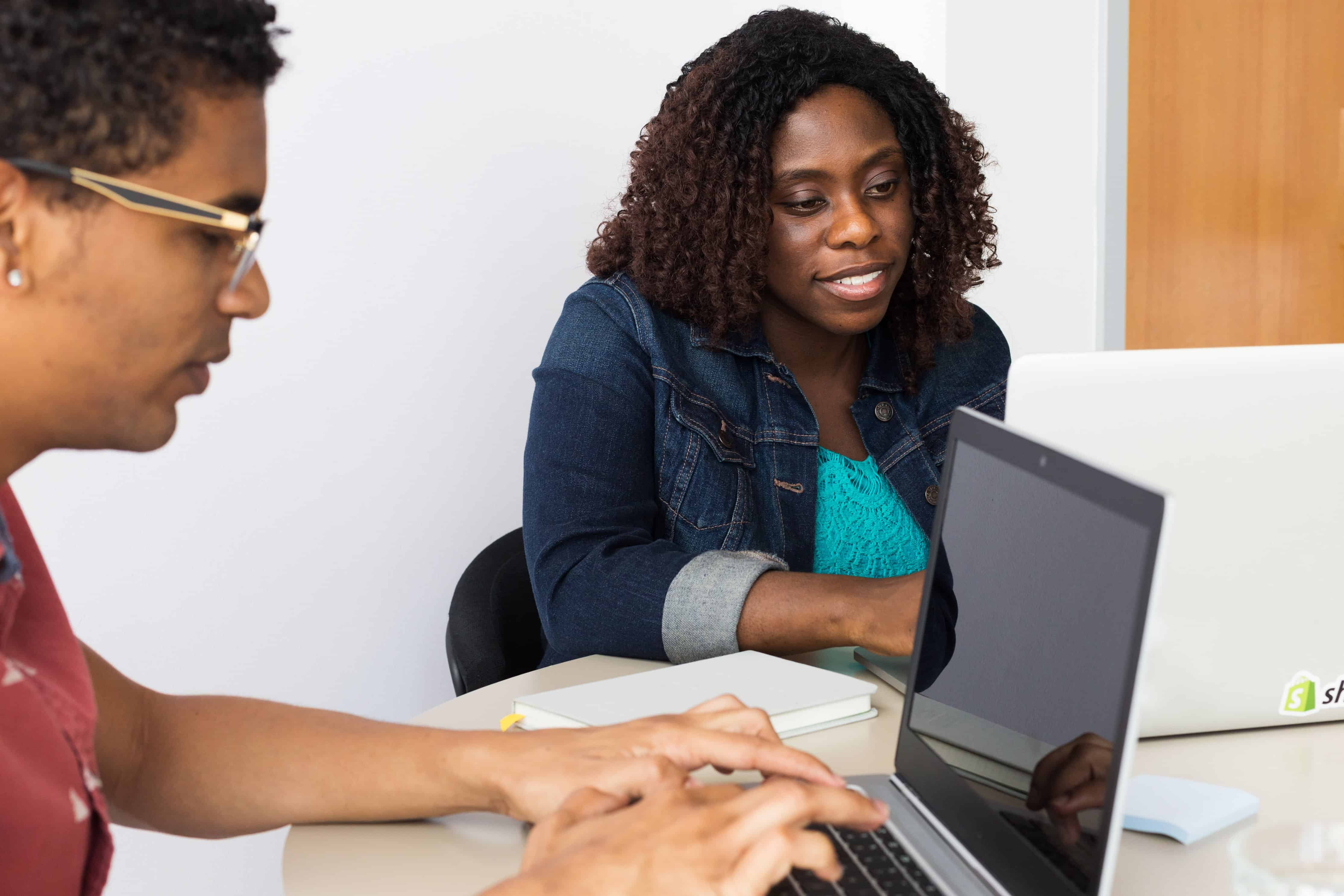 two people working on laptops